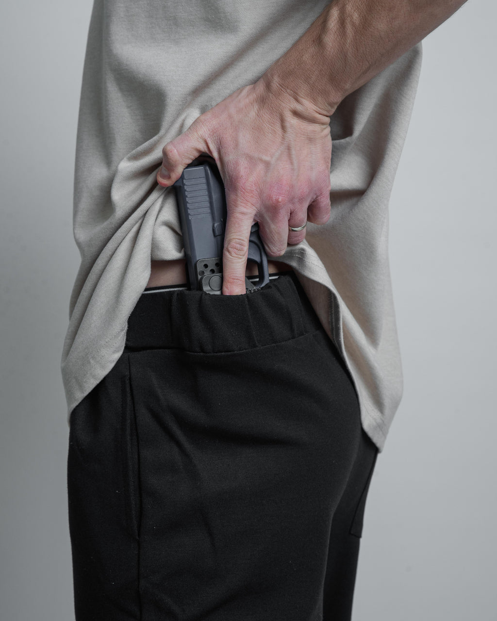bluegun in holster with hand on it.
black armato pants
