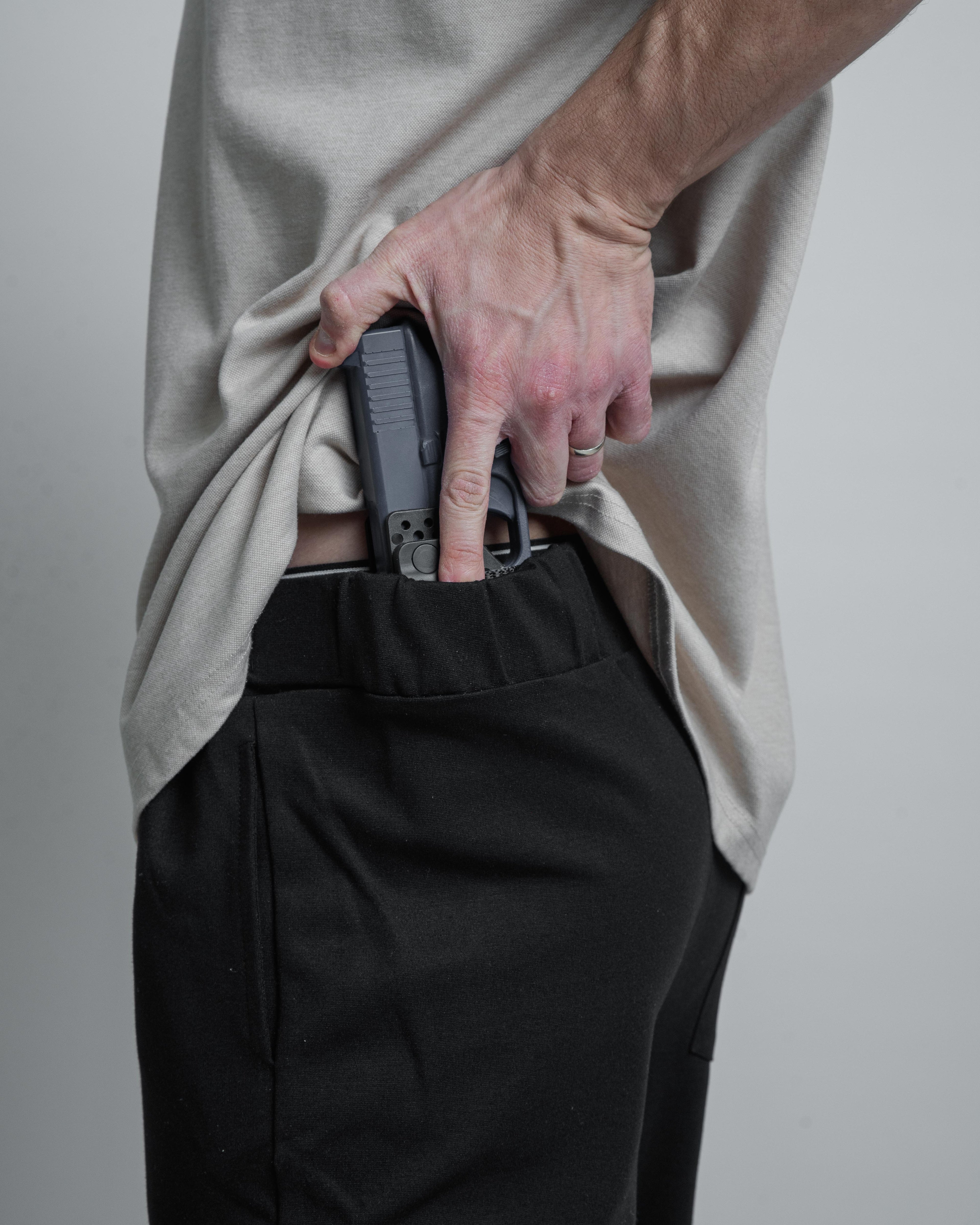 bluegun in holster with hand on it.
black armato pants