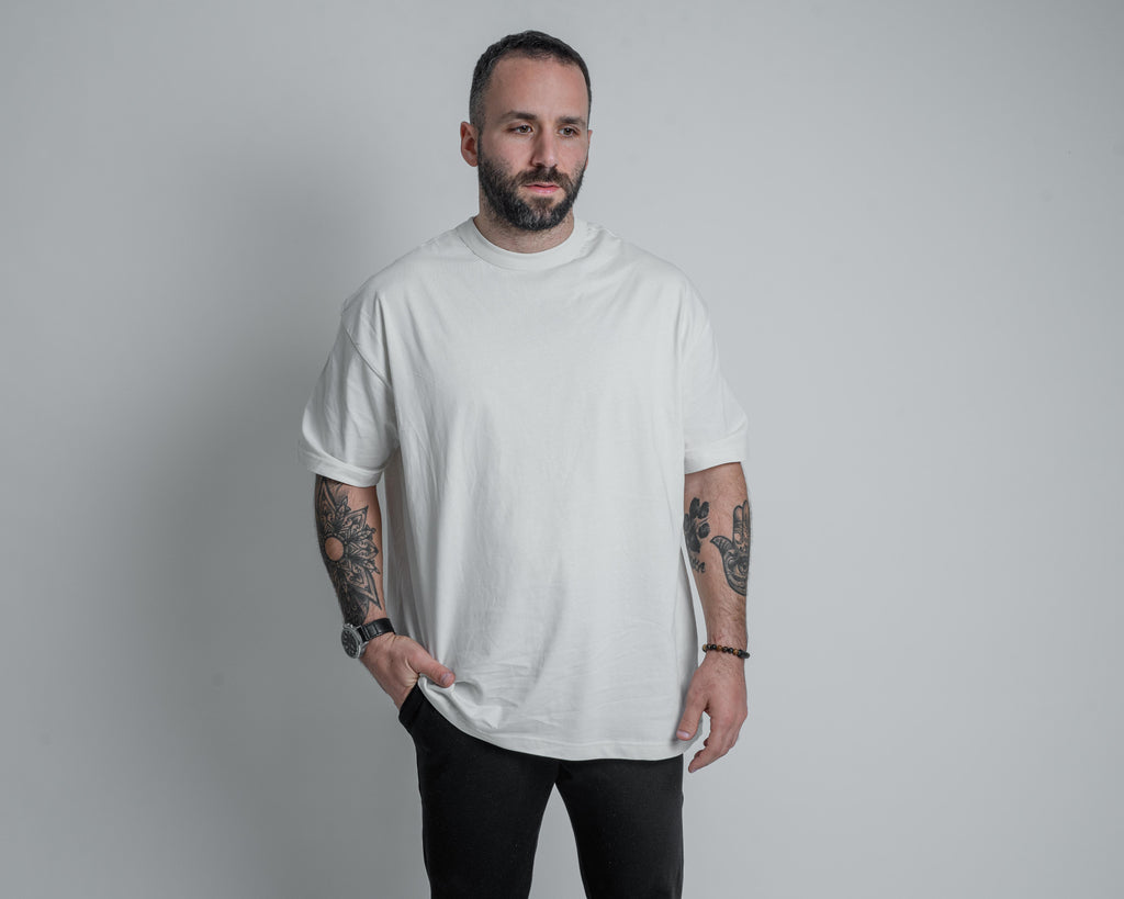 a model wearing a white shirt with armato black pants and one hand in pocket